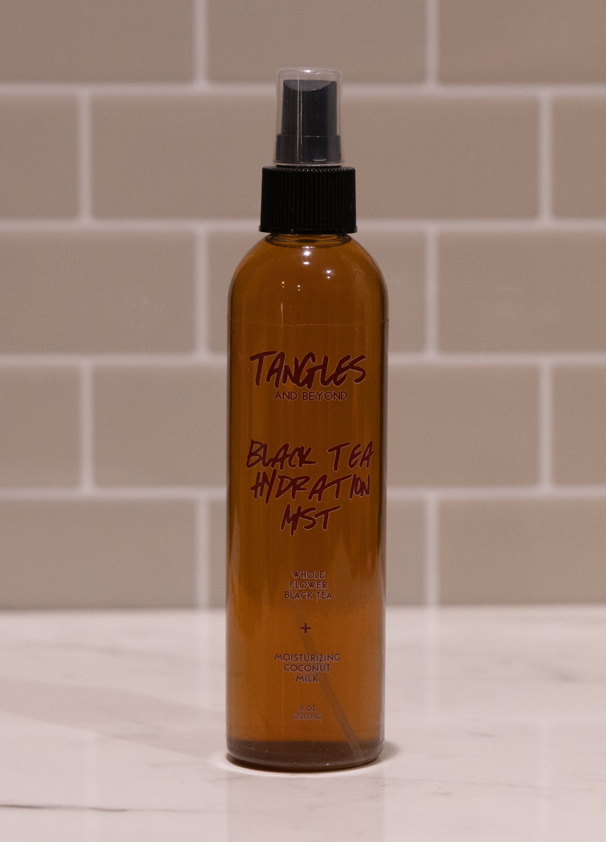 Bottle of Tangles Black Tea Hydration Mist on a tiled bathroom counter