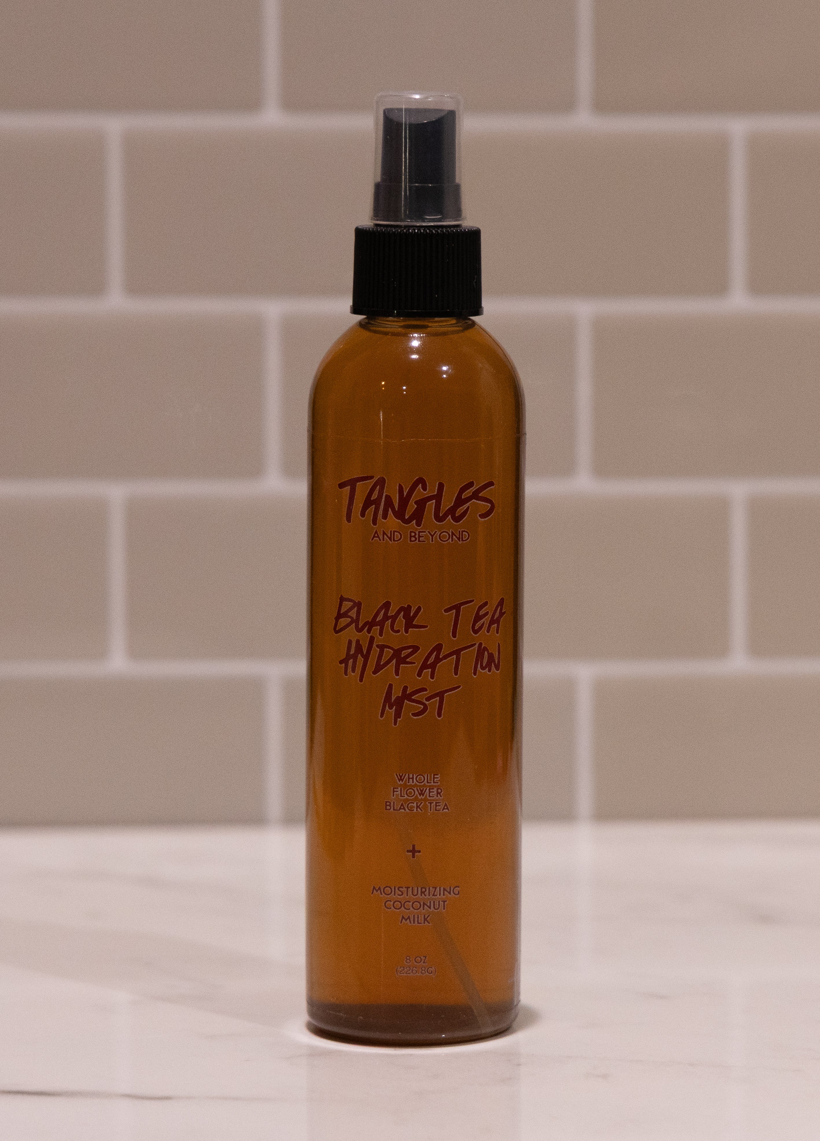 Bottle of Tangles Black Tea Hydration Mist on a tiled bathroom counter