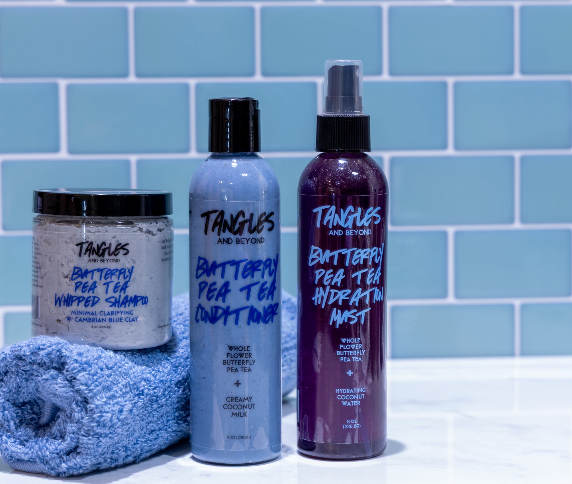 Tangles and Beyond hair care products on a tiled bathroom counter