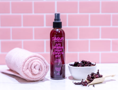 Tangles hair product bottle with a towel and bowl on a pink tiled background