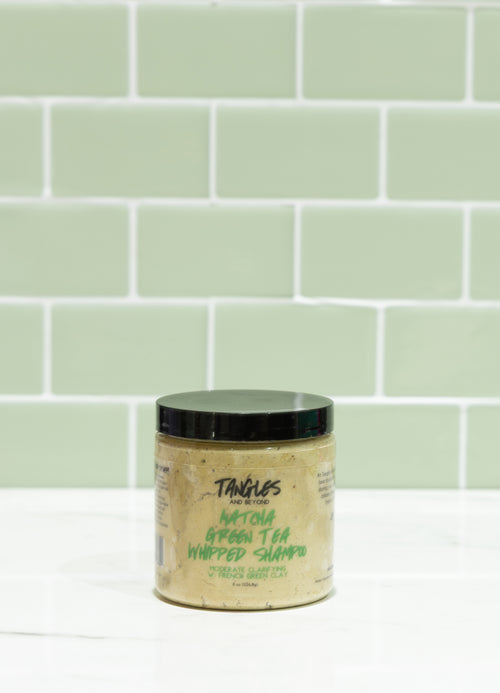 Jar of Tangles Whipped Shampoo against a light green tiled wall