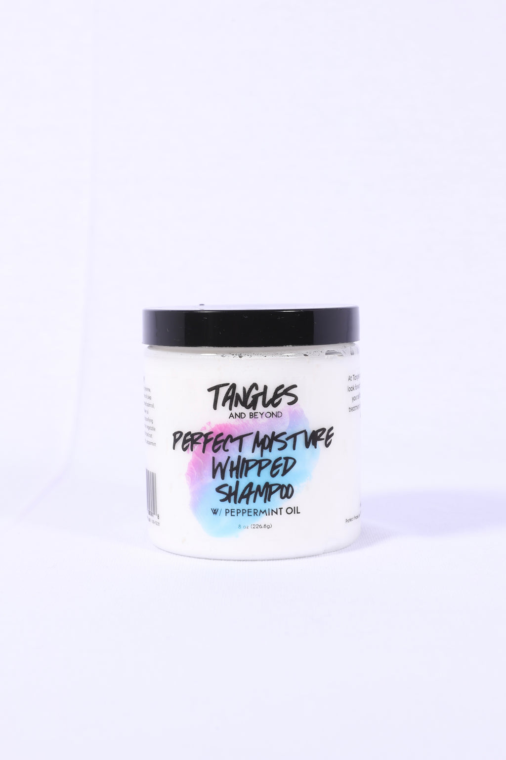 A jar of Tangles and Beyond Perfect Moisture Whipped Shampoo with a label that includes the product name and a brief description, set against a white background.