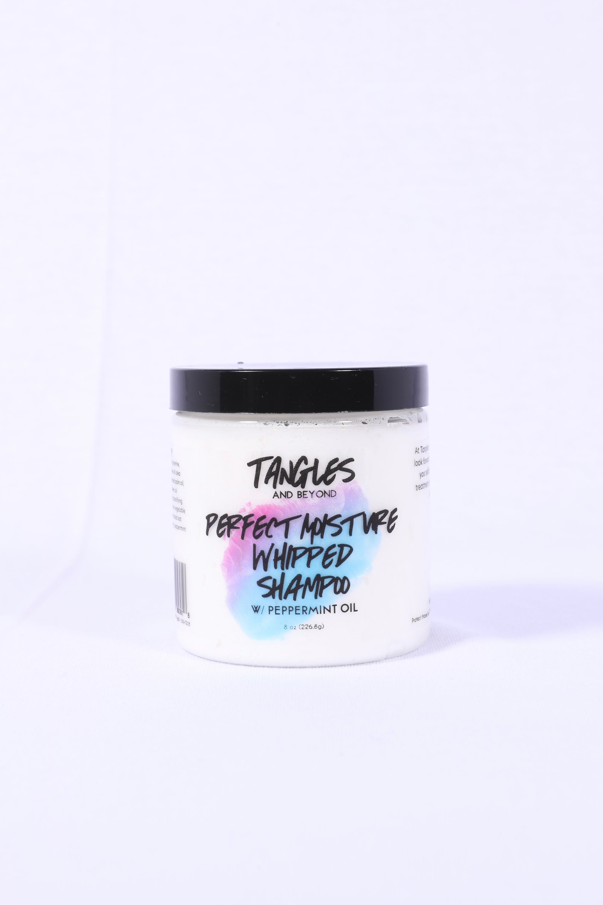 A jar of Tangles and Beyond Perfect Moisture Whipped Shampoo with a label that includes the product name and a brief description, set against a white background.