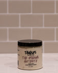 Jar of 'Tangles and Beyond The Original Antidote' cream on a tiled bathroom counter.