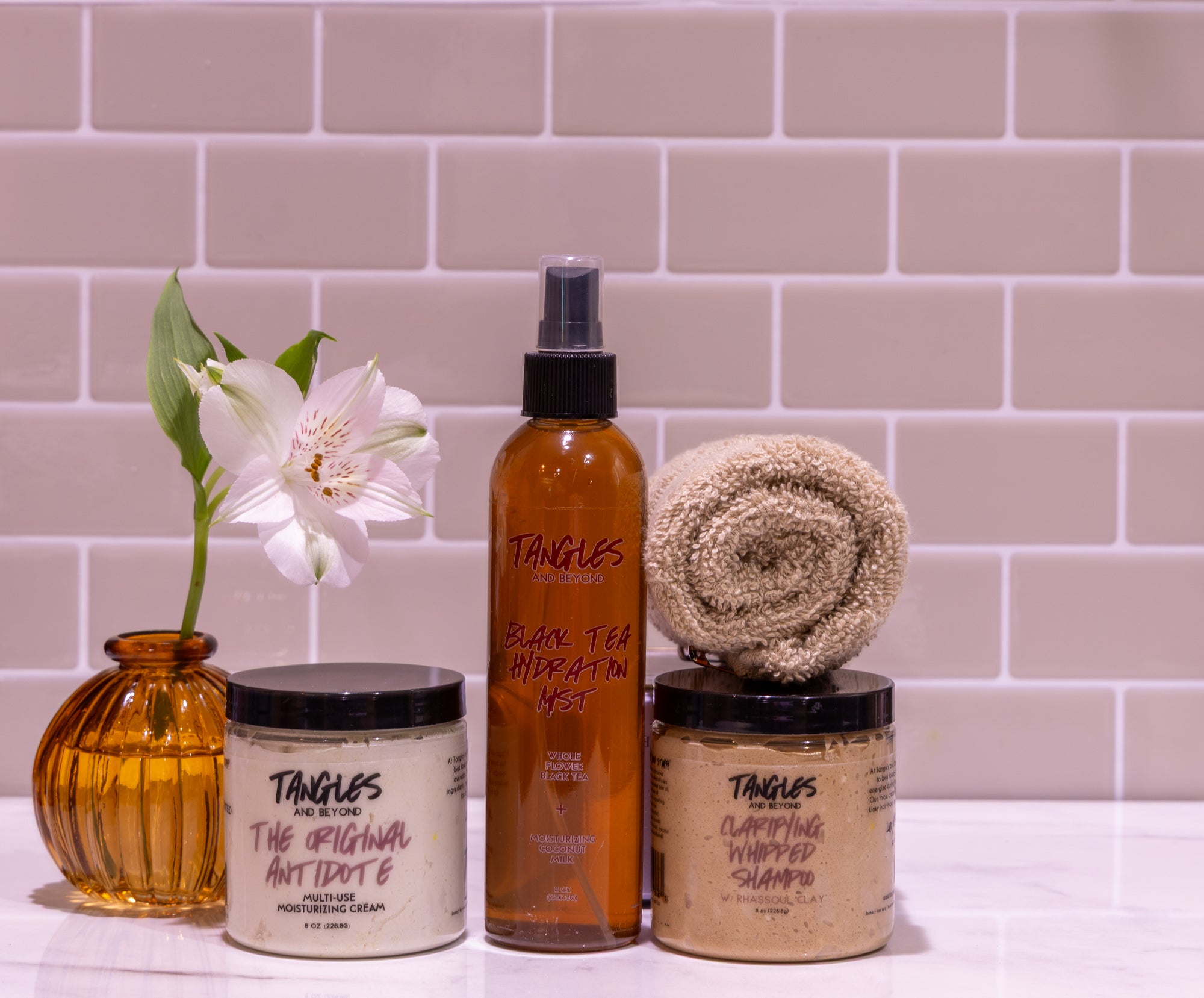 Bathroom setting with Tangles hair care products against a tiled wall.