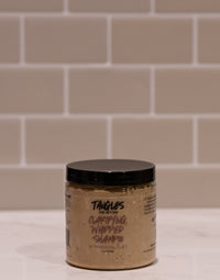 Jar of Tangles shampoo on a tiled bathroom floor