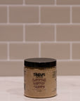 Jar of Tangles shampoo on a tiled bathroom floor