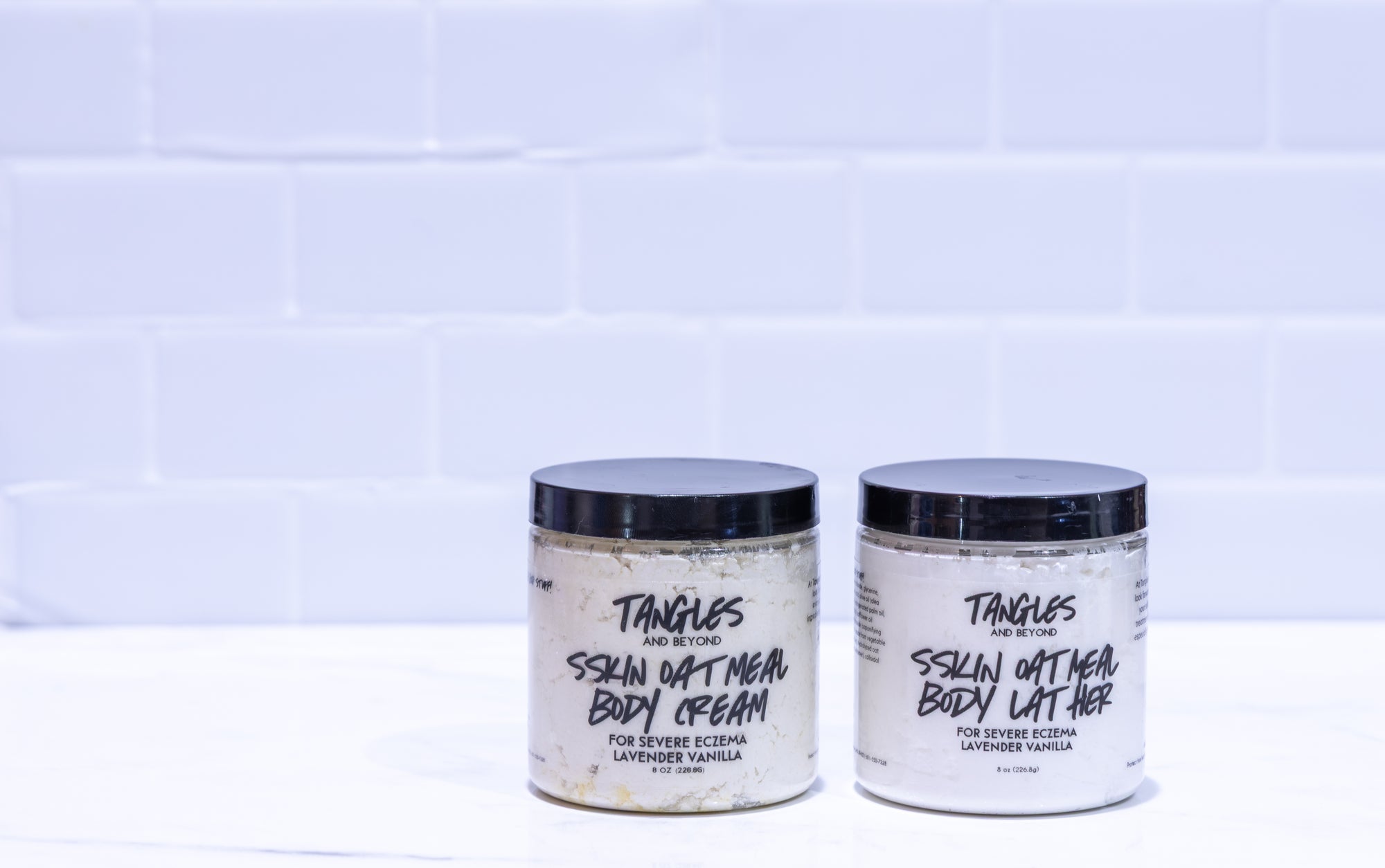 Two jars of 'Tangles and Beyond SSKIN' body cream on a white background with a tiled wall.