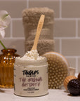 Cosmetic product with a wooden spoon and decorative items on a bathroom counter.